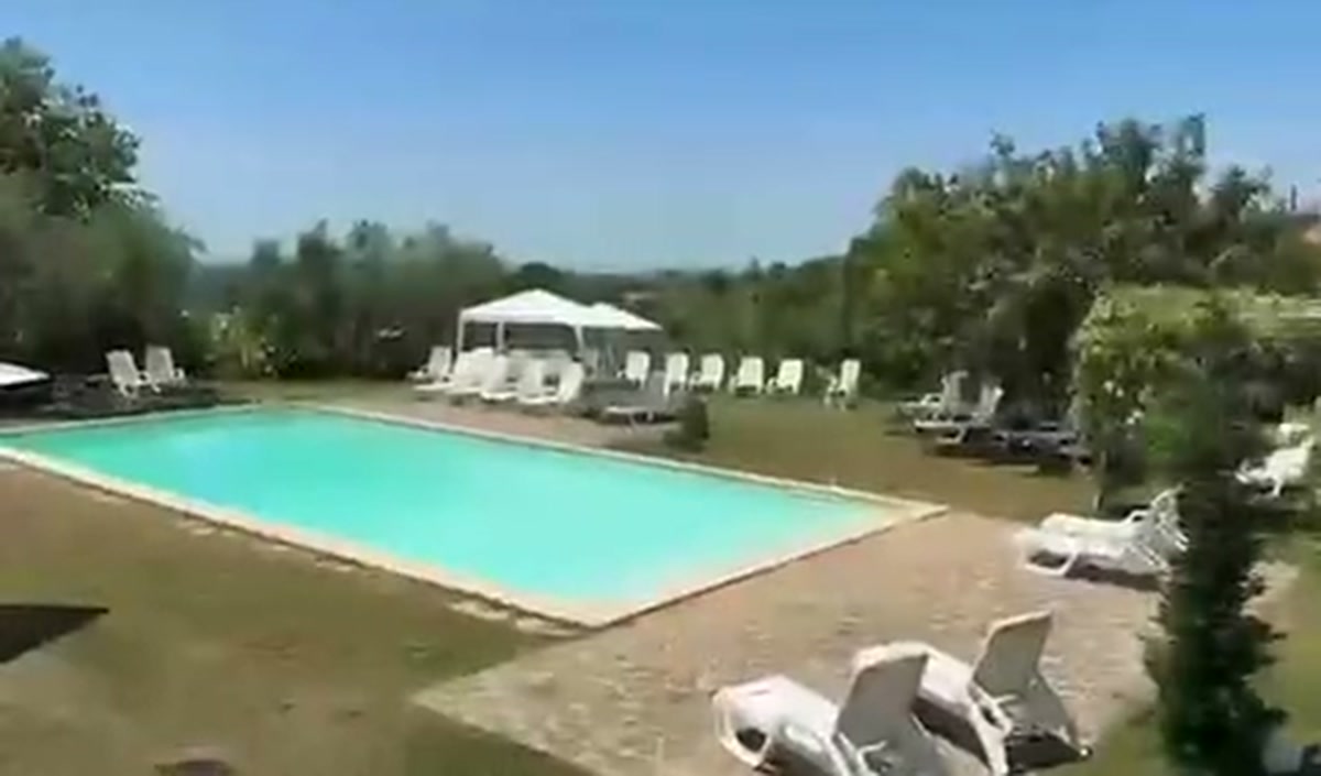 La piscina della tenuta con i lettini e il prato intorno